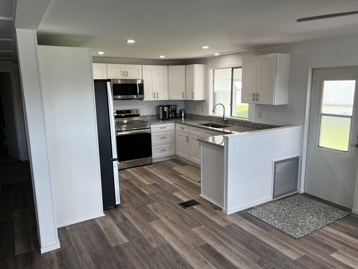 Kitchen remodel after — modern white shaker cabinets, granite countertops, Monticello FL